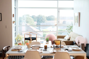 Compact apartment or condo living room with sofa, chair, table, window, and dining setup.