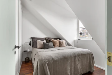 Bedroom with bed, window, wood furnishings, and home decor.
