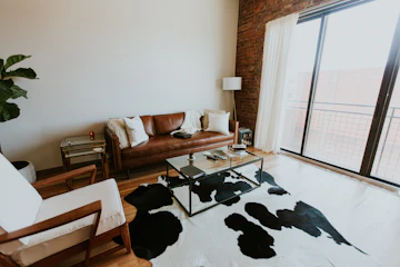 Mid-century loft living room with sofa, plants, lamp, and coffee table.
