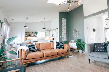 Comfort-focused living room with a couch, plants, pillows, and open-plan interior.